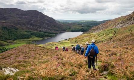 Ramblers group walking to Llyn Cwm Bychan in Rhinog mountains of Snowdonia National Park